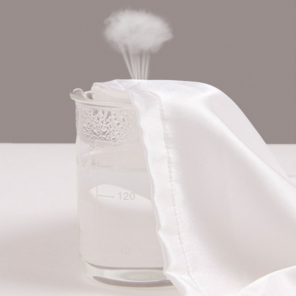 White satin fabric draped over a glass beaker
