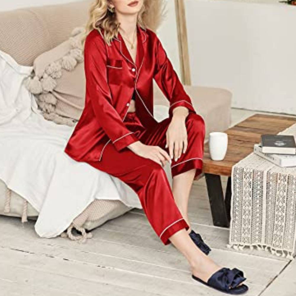 Woman in the red satin pyjama set sitting on a sofa